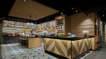 A modern kitchen with a central island, bar stools, and a patterned floor.