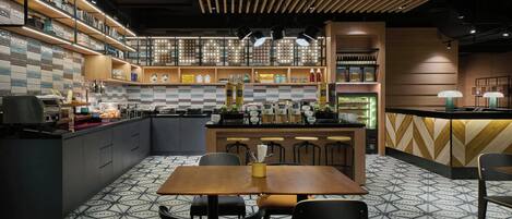 Una cocina moderna con una isla central, taburetes de bar y una zona de comedor con sillas.