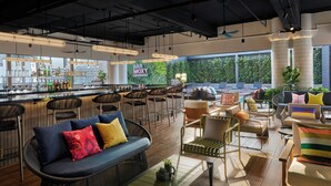 A modern bar area with seating and a bar counter. - Moxy Kuala Lumpur Chinatown (Kuala Lumpur)