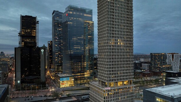 A high-rise building with a grid-like facade and illuminated windows. - New Hotel Moxy Montreal Downtown (Montreal)