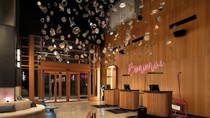 A lobby with a reception desk, a sofa, and a coffee table. - New Hotel Moxy Montreal Downtown (Montreal)