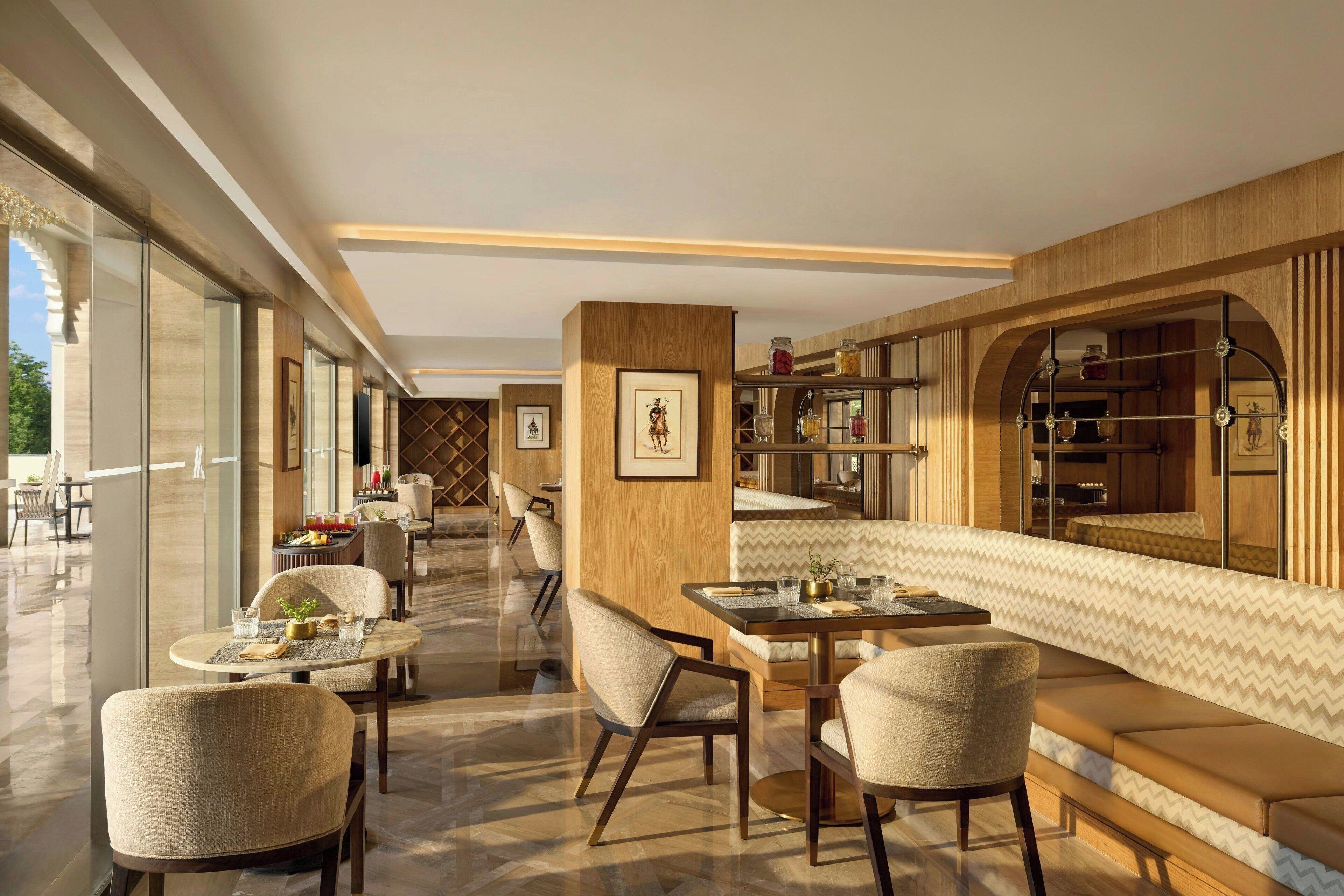 A modern dining area with round tables, cushioned seating, and a view of the outdoors.