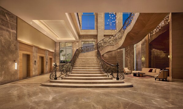Stunning staircase with ornate metal railings and large windows.