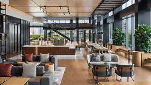 A spacious hotel lobby with a central bar area, seating arrangements, and large windows offering views of the cityscape. - Sheraton Grand Xiamen Jimei (Xiamen)