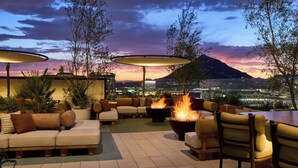 A rooftop lounge area with outdoor seating, fire pits, and umbrellas. - The REMI., Scottsdale, Autograph Collection (Scottsdale)