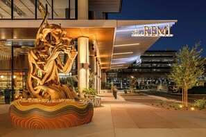 A modern hotel entrance with a large, abstract sculpture in the foreground and a prominent sign reading "The REMI". - The REMI., Scottsdale, Autograph Collection (Scottsdale)
