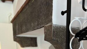 En moderne stue med en grå sofa, dekorative puder og en flettet kurv hængende på en sort metalreol.