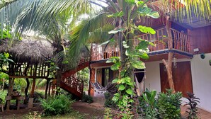 A wooden house with a thatched roof, a wooden staircase, and a hammock. - 4-bedroom house in fabulous Isla de Ometepe with AC, WiFi (Isla de Ometepe)