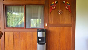 A water dispenser in front of a wooden door with a window and two decorative parrots. - 4-bedroom house in fabulous Isla de Ometepe with AC, WiFi (Isla de Ometepe)