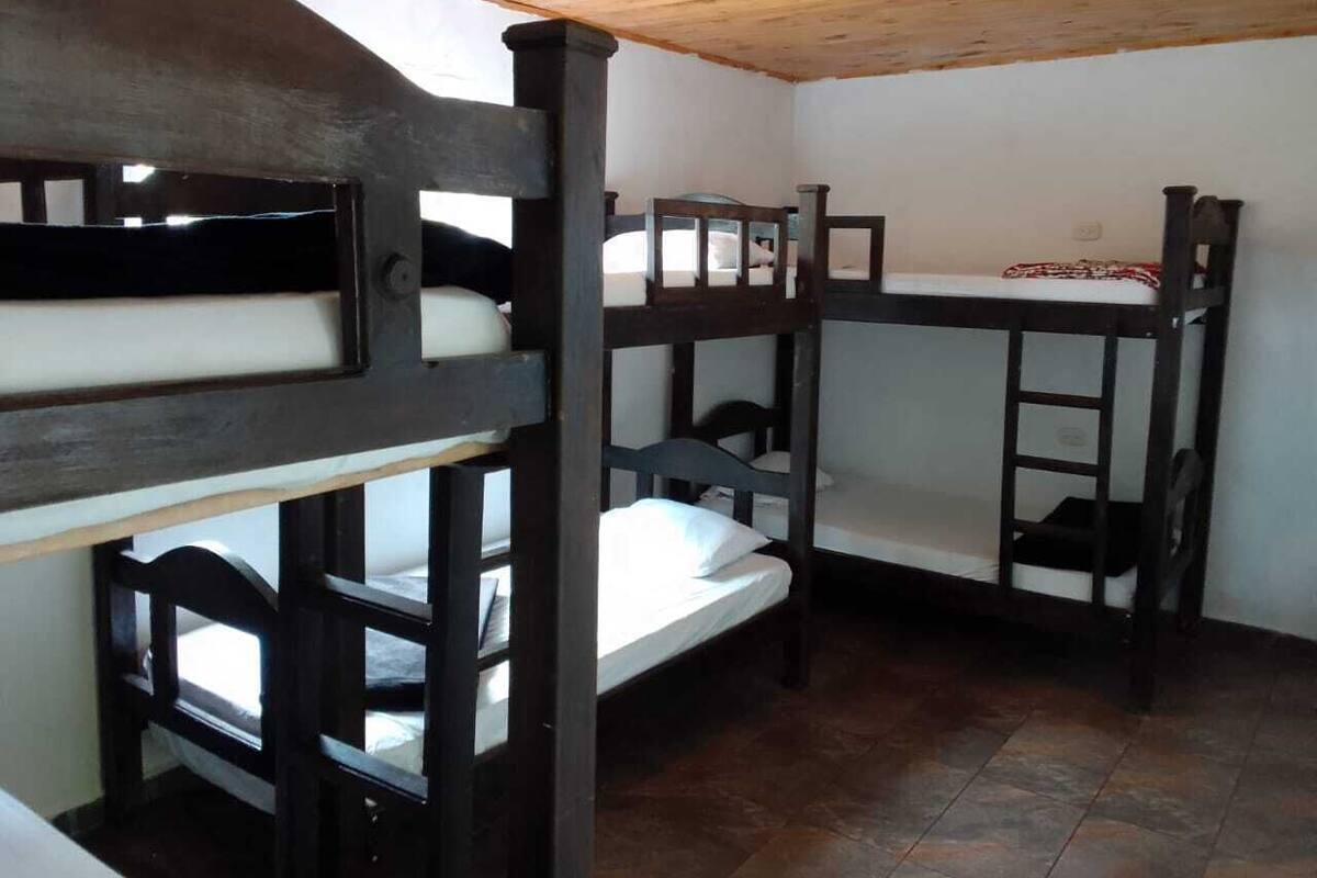A bunk bed room with wooden bunk beds and a tiled floor.