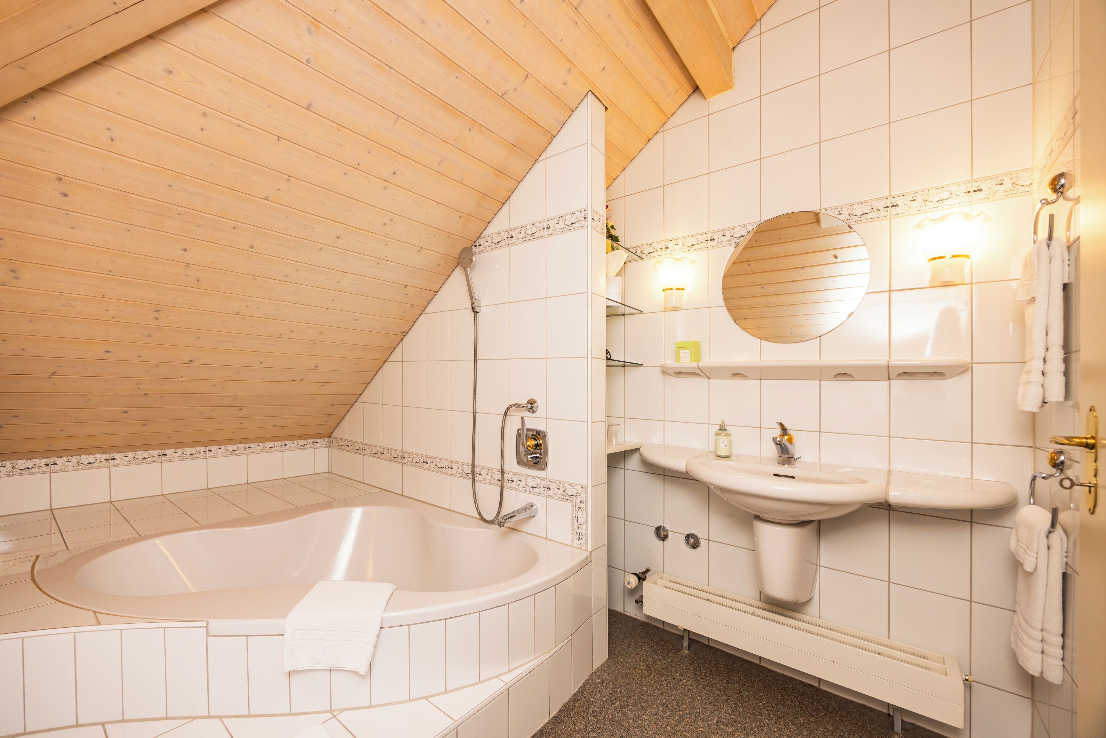 A bathroom with a freestanding bathtub, a sink, and a mirror.
