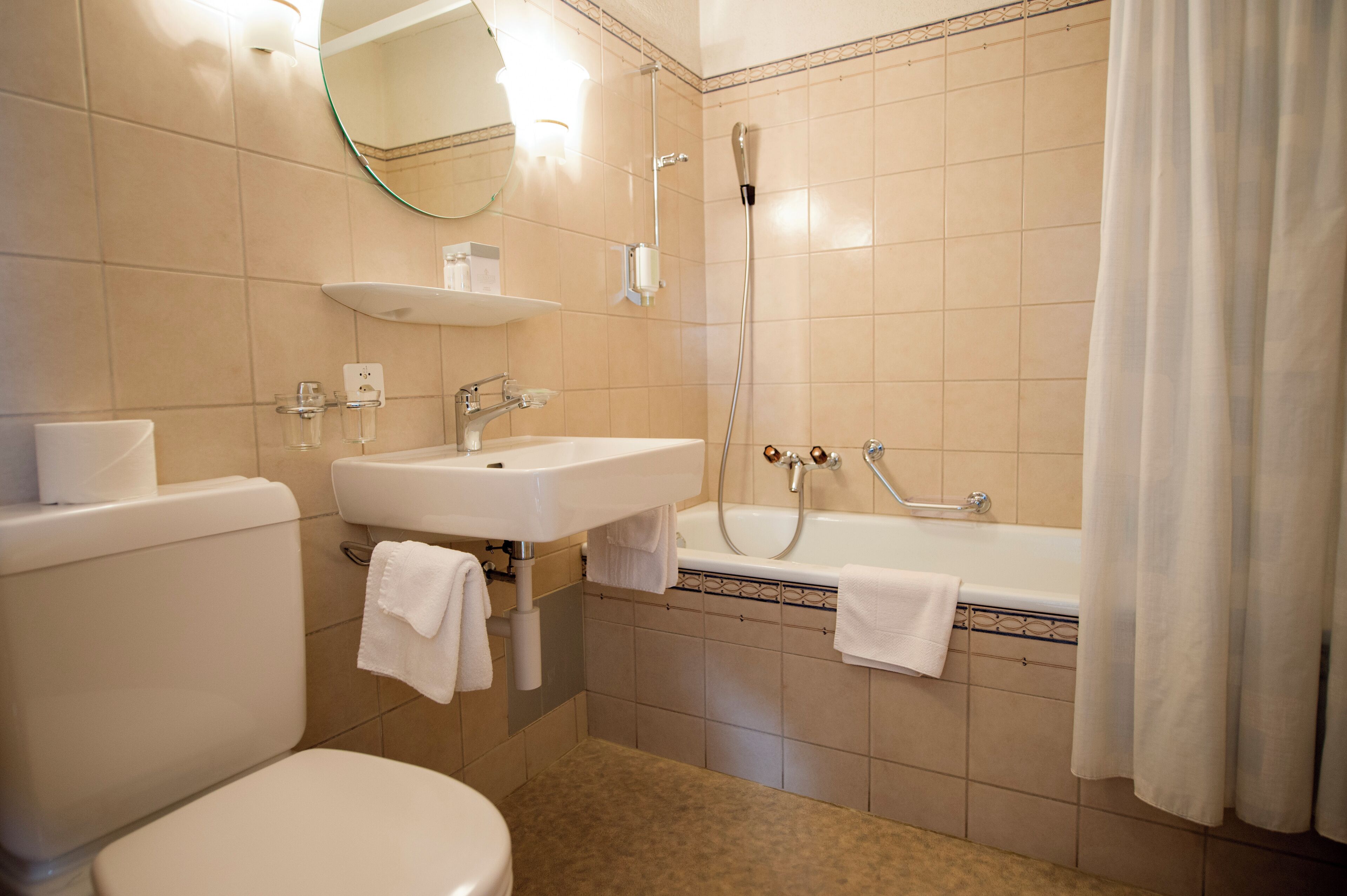 Un baño con inodoro, lavabo, bañera y ducha.