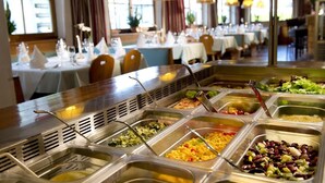 Zona de buffet amb diferents espais de menjar, incloent amanides, cereals i llegums.