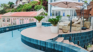A rooftop pool with a curved edge, lounge chairs, and potted plants. - Hotel Río Guayas by Art Hotels Ecuador   (Guayaquil)