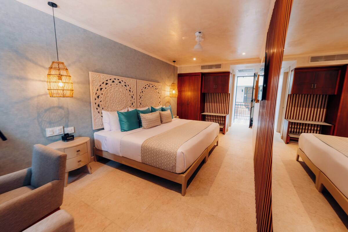 A bedroom with a bed, bedside tables, a chair, and a wardrobe.