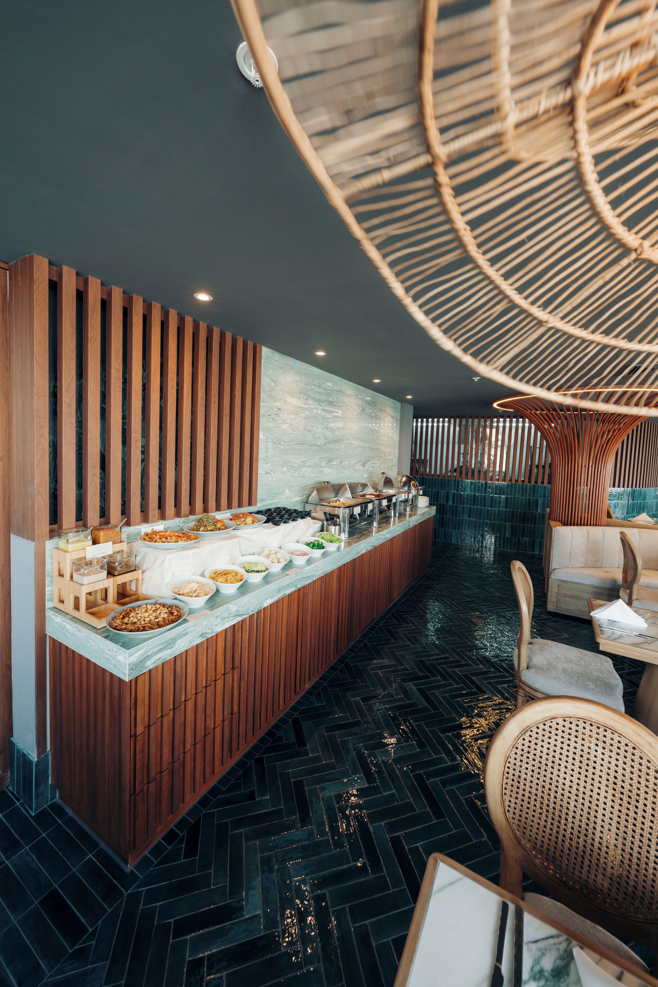 Un área de bar moderna con una barra de madera, asientos y un diseño de techo singular.