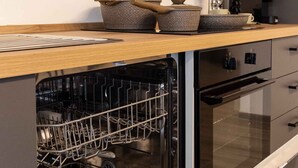 A modern kitchen with built-in appliances, a dishwasher, and a coffee maker.