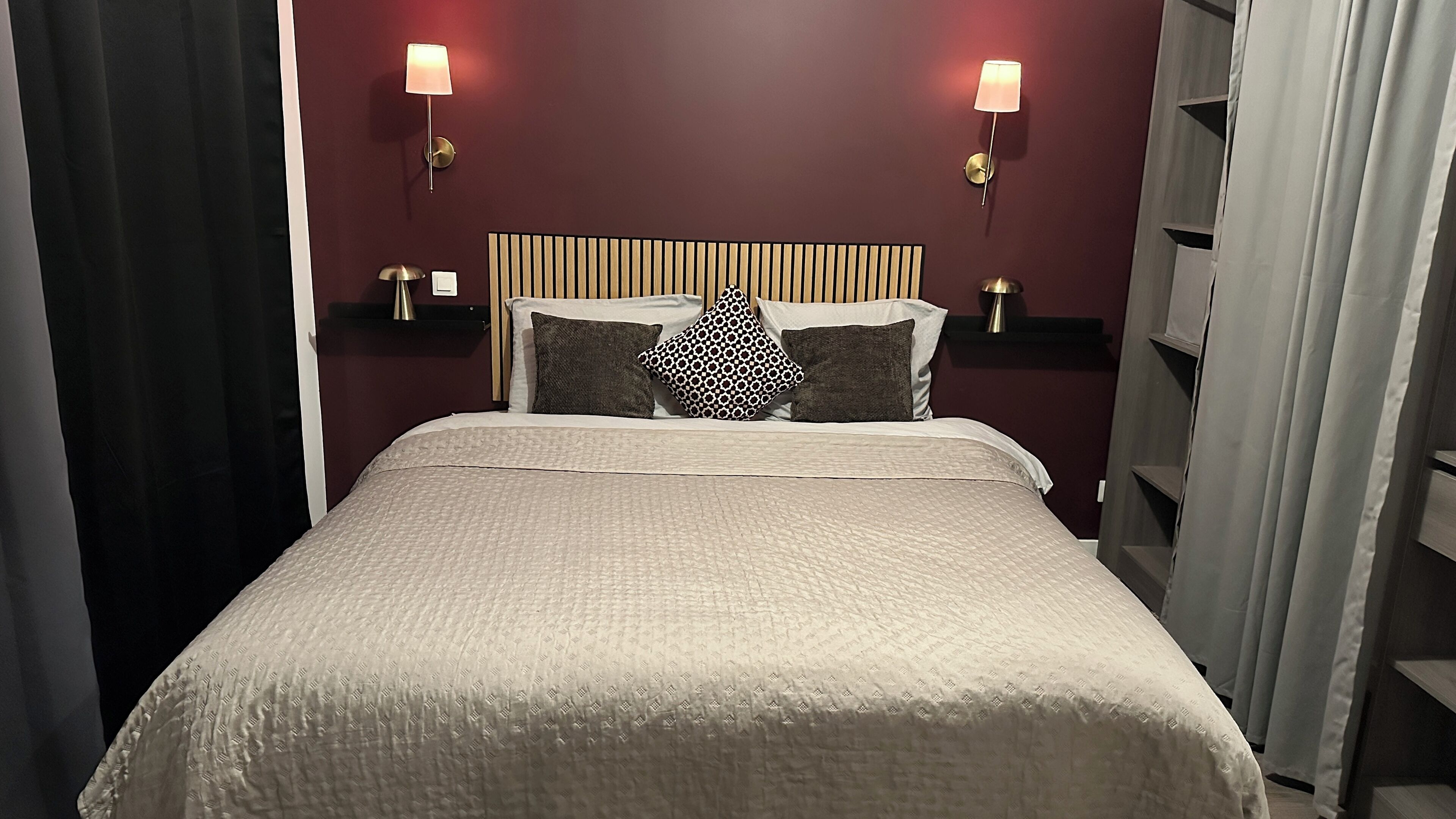 Ein Hotelzimmer mit einem Bett, zwei Nachttischlampen, einem Kopfteil und einem Nachttisch.