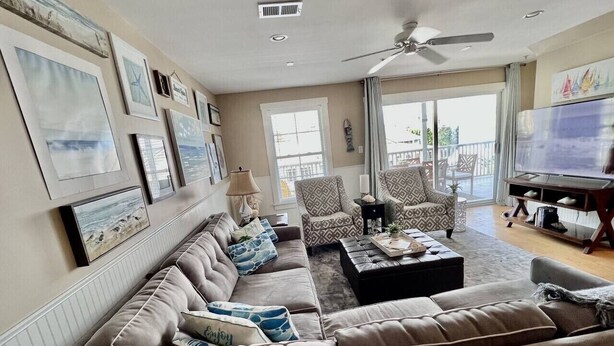 A living room with a sofa set, a coffee table, and a television.