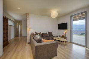 A modern living room with a sofa, a coffee table, and a TV mounted on the wall.