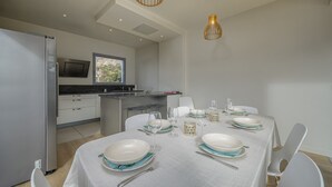 Une cuisine moderne avec un coin repas aménagé pour accueillir six personnes.