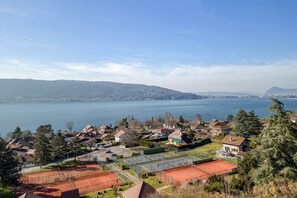 A residential area with houses, a tennis court, and a lake. - Wooden Villa 4* (Veyrier-du-Lac)