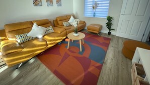 Un salon comprenant un ensemble de canapés, une table basse et un tapis à motifs.
