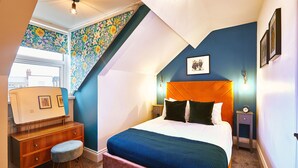 Une chambre à coucher avec un lit, une table de chevet, une commode et une fenêtre.