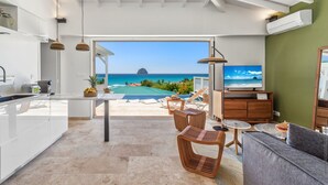 A modern kitchen with a view of the ocean, a dining area with a pool, and a living room with a TV. - Cézembre (Le Diamant)