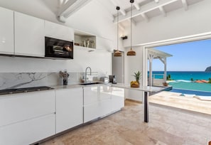Enjoy a serene ocean view from the kitchen, which opens to a spacious patio.
