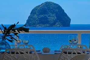 Dine with a view of the ocean and a distant island from this serene dining area.