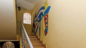 A staircase with a handrail and a wall with abstract art. - Nefertiti pyramids (Giza)