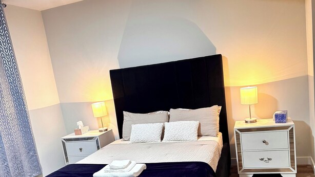 Una camera da letto ordinata con un letto grande, due comodini e un tavolino.