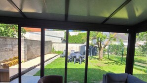 A modern living room with a large sliding glass door leading to a backyard. - Renovated and elegant Ledoux Land house near Disney and 45 min from Paris (Bailly-Romainvilliers)