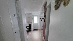 A hallway with wooden flooring, white walls, and a door leading to a room. - Renovated and elegant Ledoux Land house near Disney and 45 min from Paris (Bailly-Romainvilliers)
