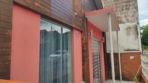 A building with a red facade, large glass windows, and a visible door.