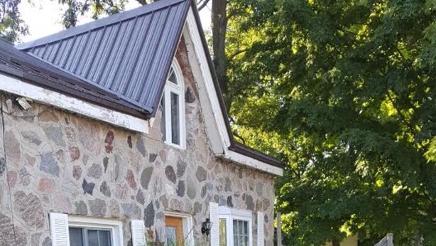 Een stenen huis met een pad van stenen dat naar een deur leidt.