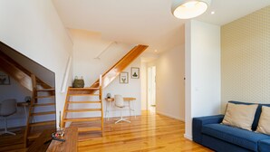 A modern interior with a wooden staircase, a blue sofa, and a wooden dining table. - Arroios Concept VI by Homing (Lisbon)