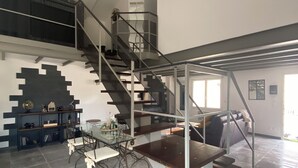 A spacious living area with a staircase, a dining table, and a sofa. - House with swimming pool in Vaison-la-Romaine, Provence (Vaison-la-Romaine)