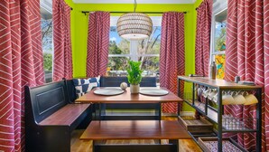 A dining area with a wooden table, bench seating, and a hanging light fixture. - Pickleball & Heated Pool & Game Room & Mini Golf (San Antonio)