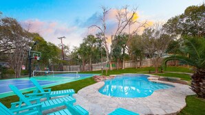 A backyard with a swimming pool, a tennis court, and outdoor seating. - Pickleball & Heated Pool & Game Room & Mini Golf (San Antonio)