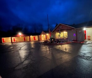 Ett motell med flera rum, en parkeringsplats och en flaggstång.