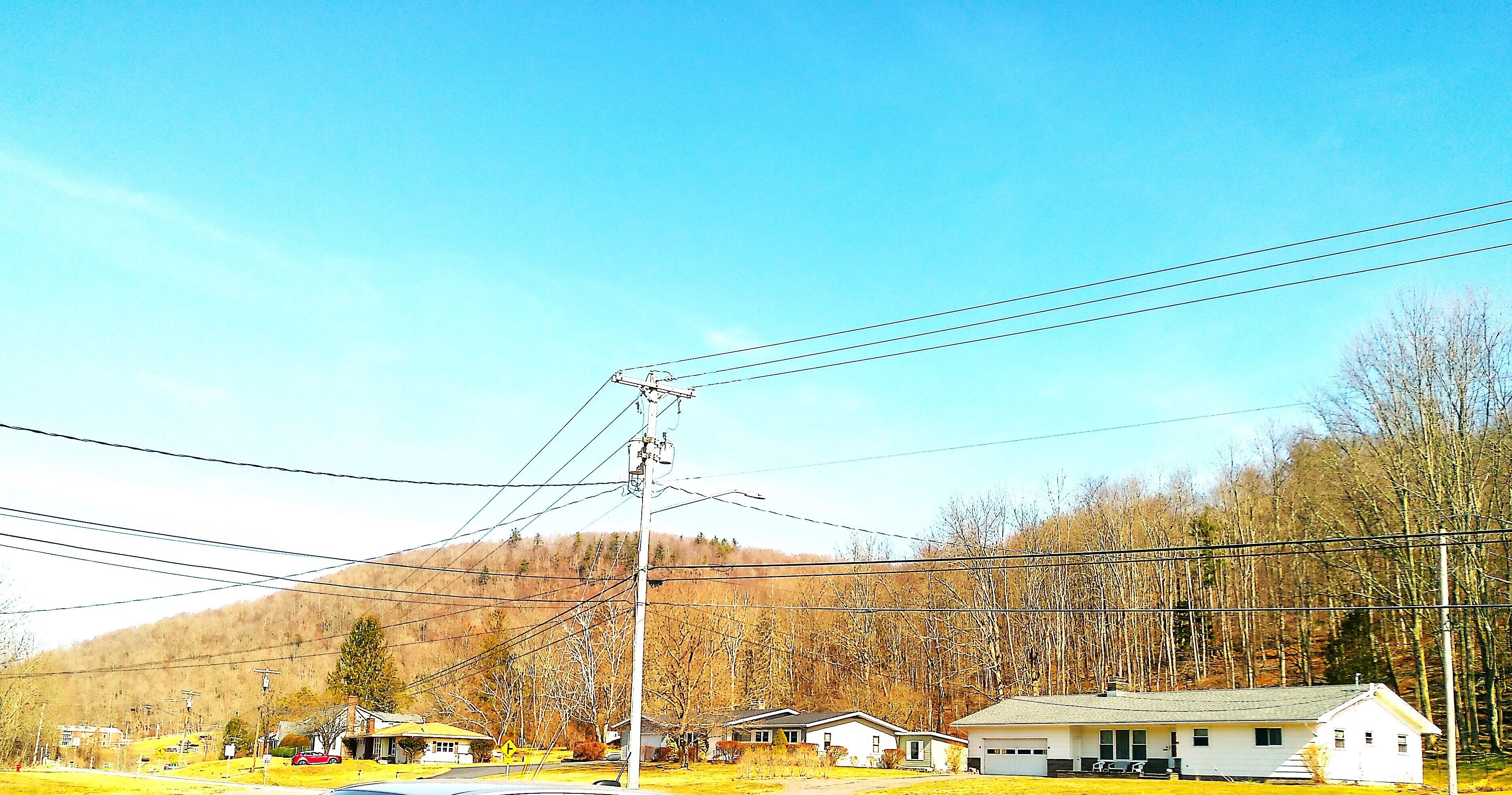 Un quartier résidentiel avec des maisons, une route et des lignes électriques.