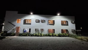 A two-story building with multiple windows, a staircase, and a gravel driveway. - Hotel Caminos (Chignahuapan)