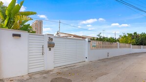 Área residencial murada com parede branca, caixa de correio e placa com o número 3B.