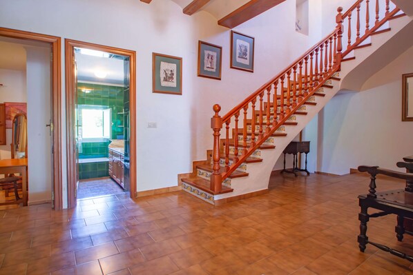 Un escalier avec des balustres en bois et une main courante, menant à l’étage supérieur.