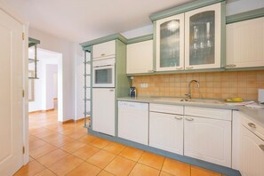 A kitchen with white cabinets, a dishwasher, and a tiled backsplash. - Villa Duke - Plusholidays (Calpe)