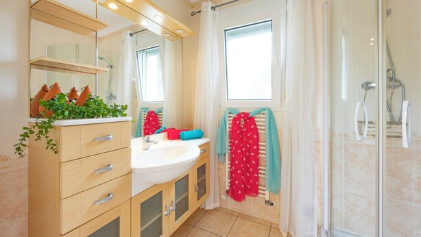 A bathroom with a sink, mirror, towel rack, shower, and a window. - Villa Duke - Plusholidays (Calpe)