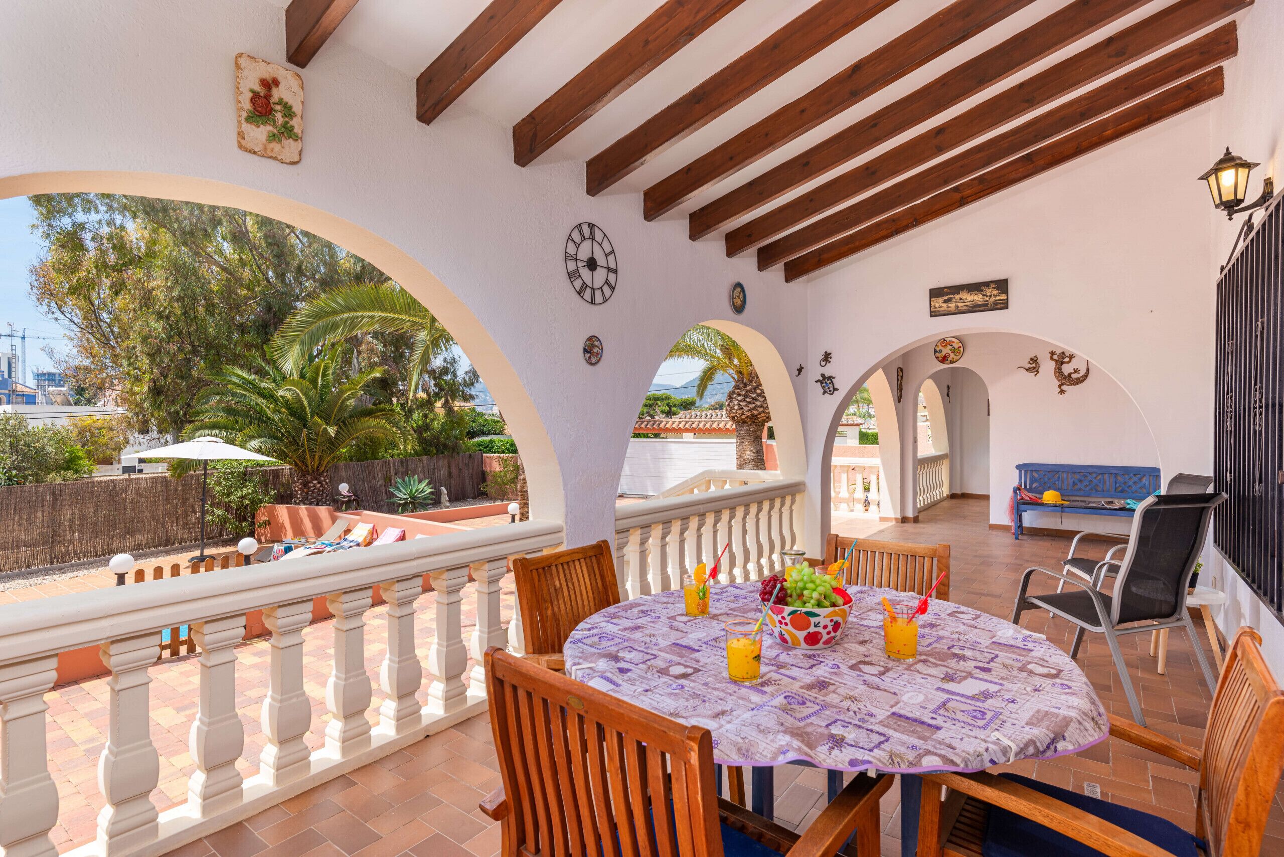 An outdoor patio with a round table, chairs, and a view of the landscape.