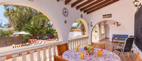 An outdoor patio with a round table, chairs, and a view of the landscape.